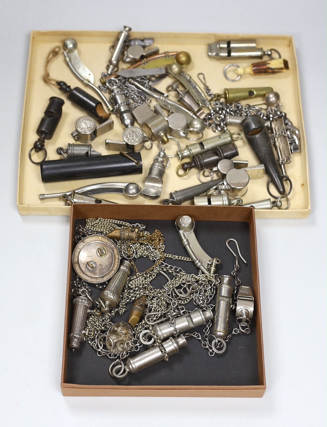A large collection of 19th/20th century plated, nickel or horn whistles and two cut steel chatelaines, including two rifle brigade whistle, chain and lion mask, boson’s whistles ACME etc.